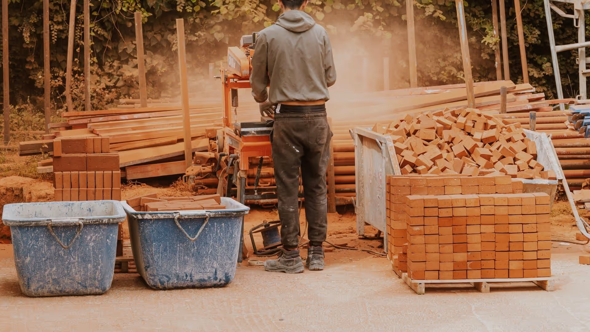 Artisan BTP devant un tas de bois — assurance decennale AGI Vincennes