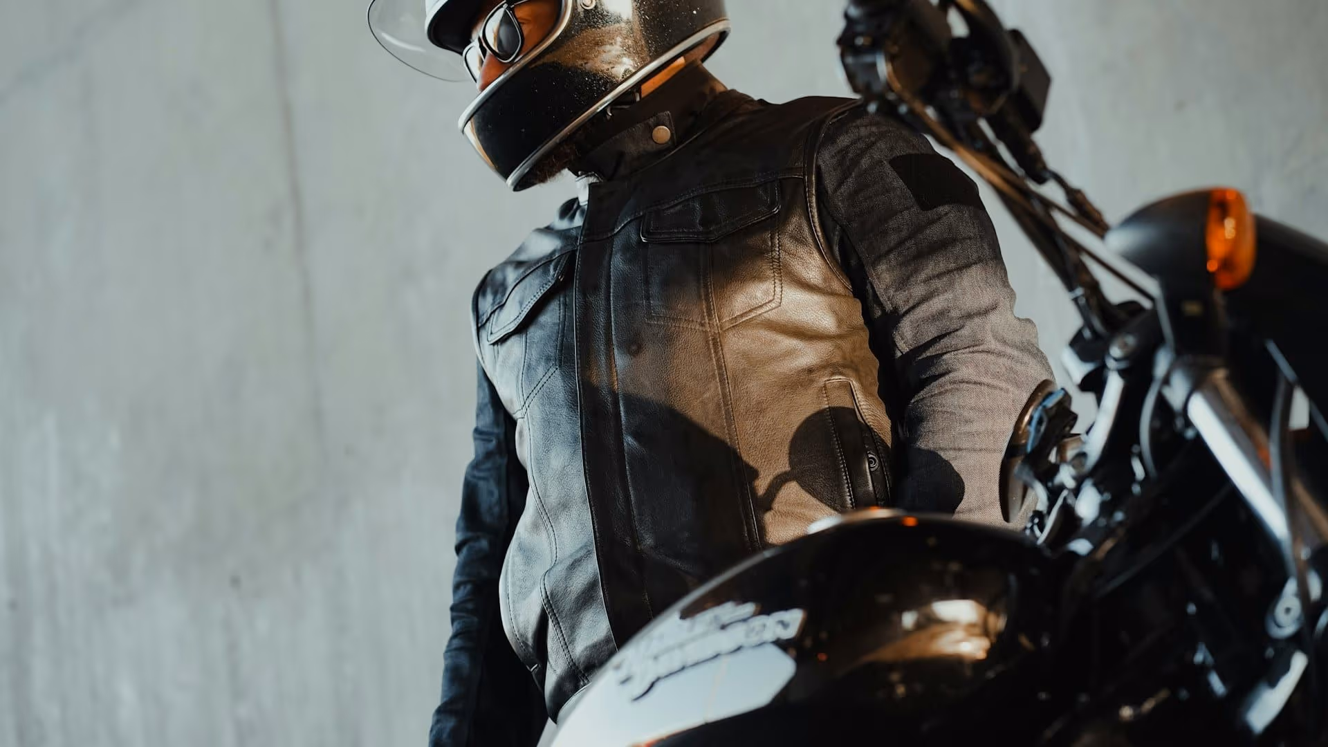 Motard en veste cuir avec casque — assurance moto resilie AGI