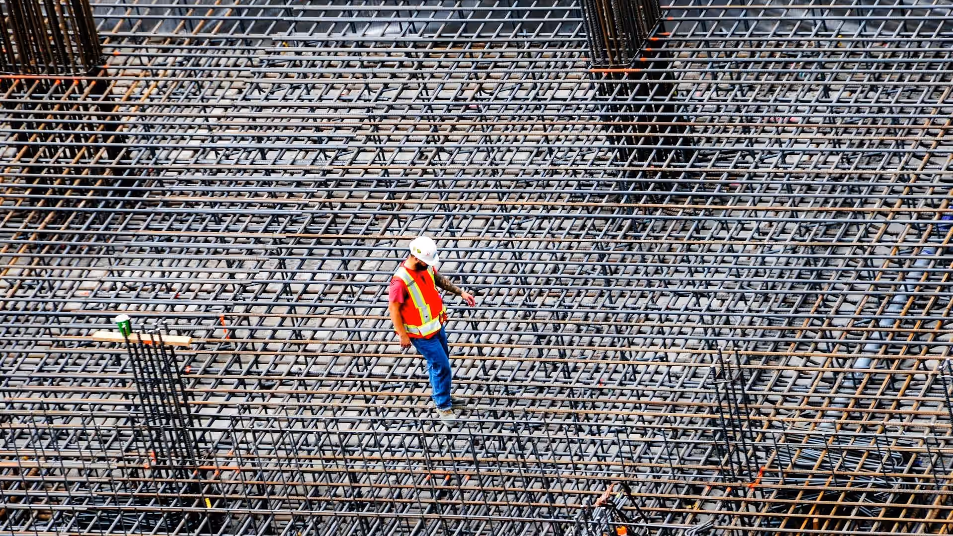 Ouvrier inspecte des barres d'armature — decennale apres resiliation AGI